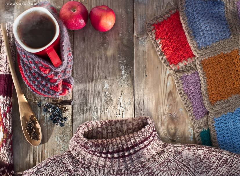 Winter composition with a mug of hot mulled wine, a sweater and a blanket