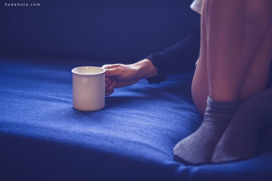 Woman sitting on sofa drinking tea