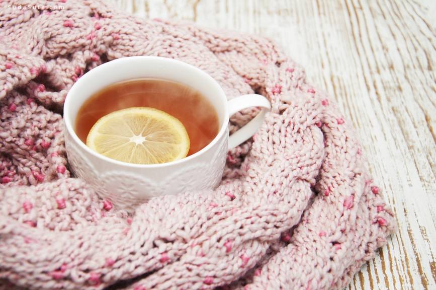 Winter time: cup of hot tea with lemon and scarf