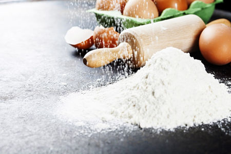 baking background with raw eggs, rolling pin and flour